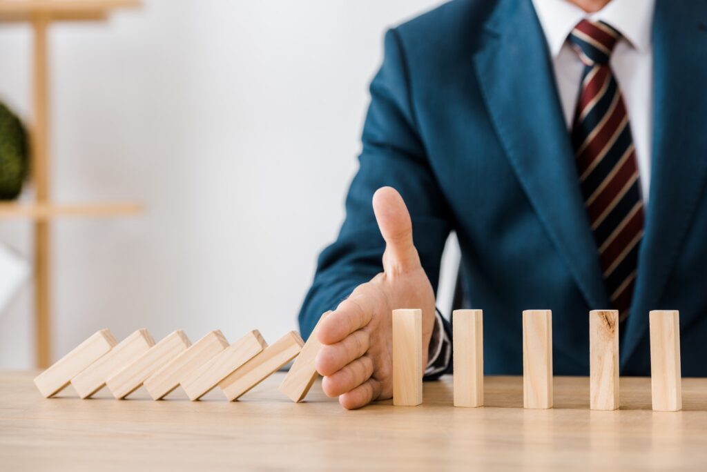 close up of businessman with blocks wood game in office, insurance concept