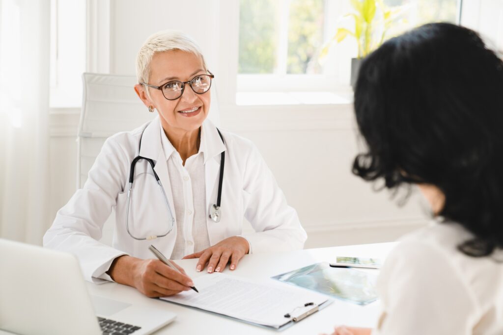 Gynecologist prescribing medicines, health insurance with female patient during hospital appointment