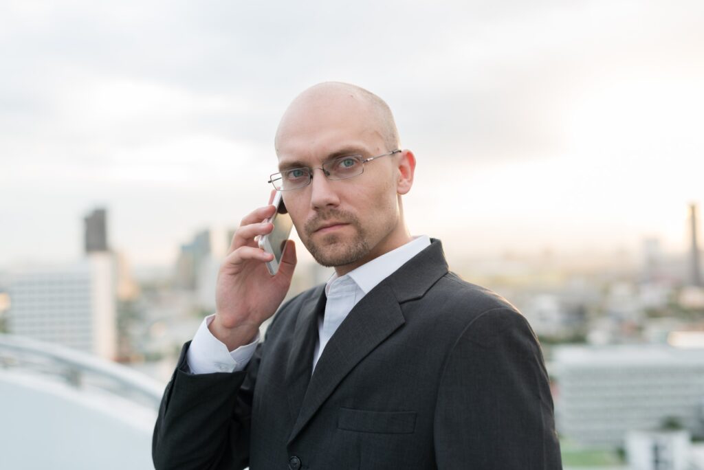 Handsome bald businessman with beard stubble against view of the city