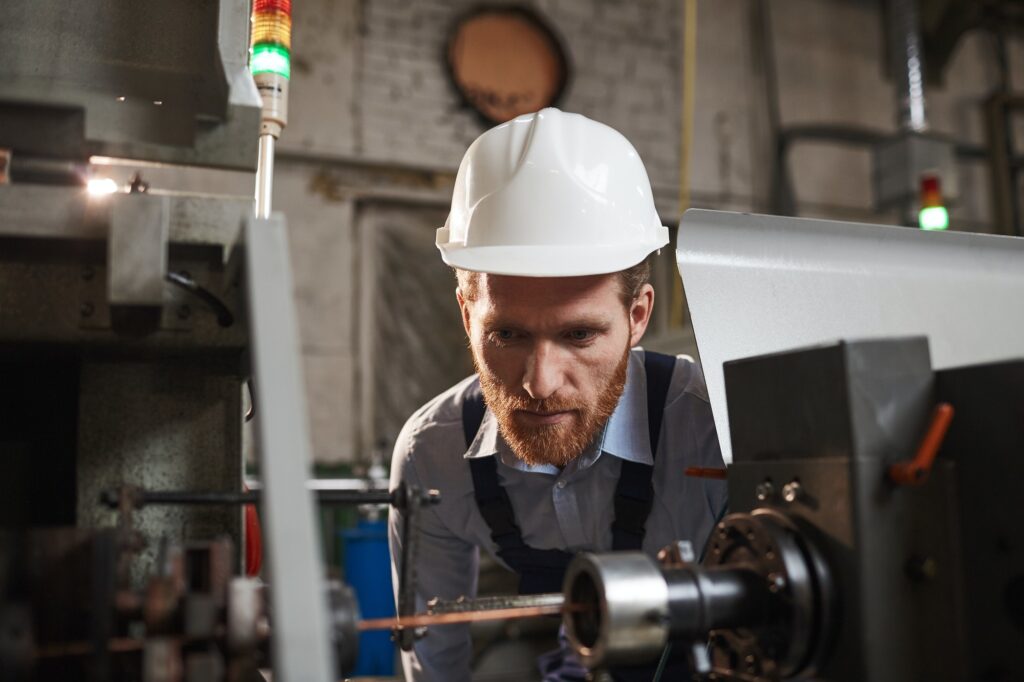 Mechanic looking at the work of machine