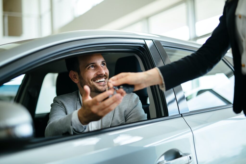 Portrait of happy customer buying new car