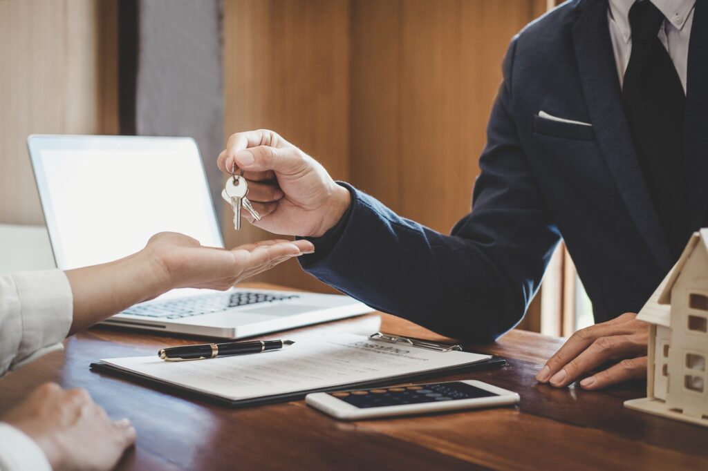 Real estate agent Sales manager holding filing keys to customer after signing rental lease contract