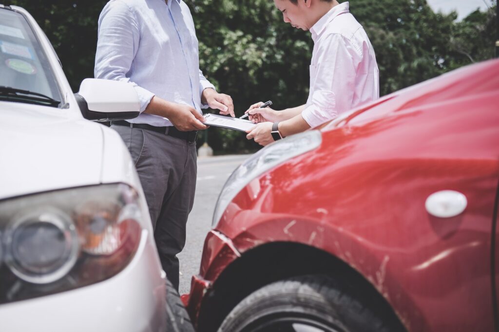 Insurance Agent examine Damaged Car and customer filing signature on Report Claim Form process after